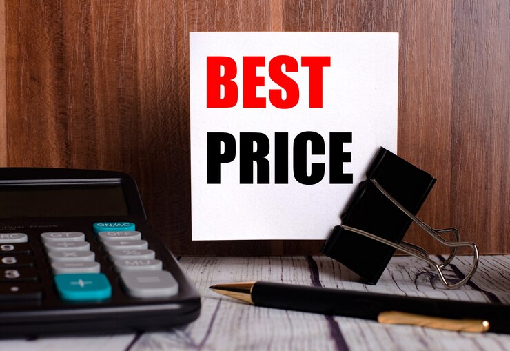 Photo best price 寫在木牆上的白色卡片上, 旁邊是計算機和筆.