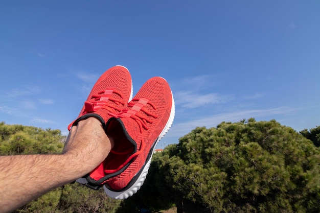 The best red running shoes raised in the air and as a background a blue sky Concept of flying