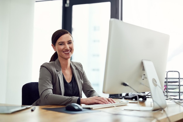 Le migliori ricompense vengono dal lavoro duro ritratto di una giovane donna d'affari che lavora su un computer in un ufficio