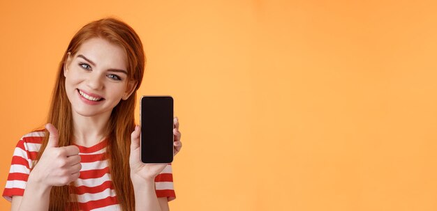 Foto la migliore app per smartphone garantisce una donna rossa dall'aspetto amichevole e assertiva che consiglia l'app per cellulare