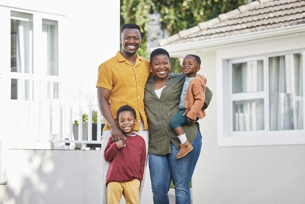 The best things in life arent things Shot of a couple standing in front of a house with their two children