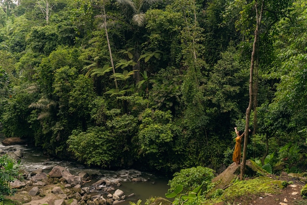 Best vacation. Cheerful brunette girl raising her arms while enjoying her freedom in wild nature