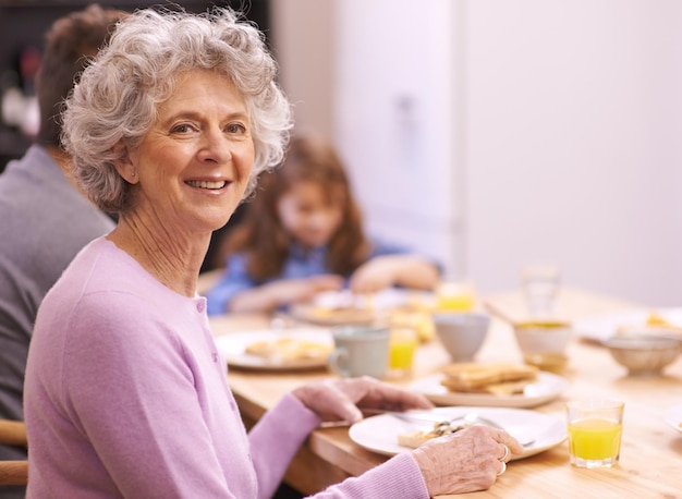 一日を始めるための最良の方法家族と一緒に朝食を楽しんでいる年配の女性のトリミングされた肖像画
