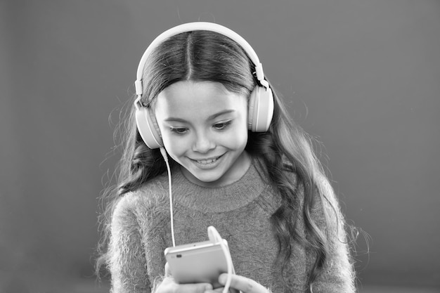 Beste gratis muziek-apps Geniet van perfect geluid Meisjeskind luister naar muziek moderne hoofdtelefoons en smartphone Luister gratis Neem een abonnement op een muziekaccount Toegang tot miljoenen nummers Geniet van muziekconcept