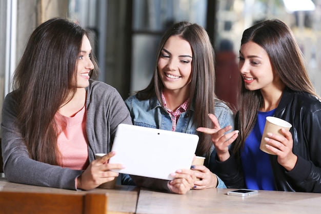 Beste vrienden met tablet samen zittend op het terras van cafés