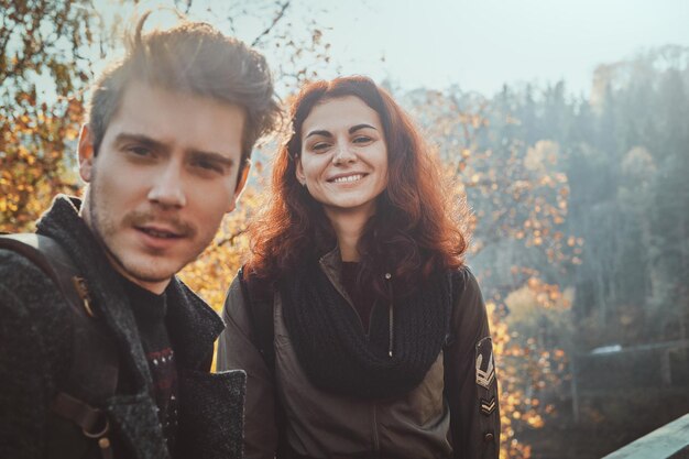 Beste vrienden poseren voor de fotograaf tijdens het wandelen in het herfstbos.
