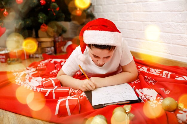 Beste wensen voor een vriend, gelukkig kind jongen die brief aan de kerstman naar huis schrijft