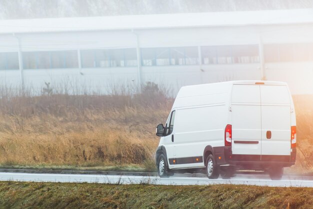 bestelwagen Een mockup van een wit bedrijfsvoertuig geïsoleerd op de weg Perfect voor uw zakelijke en verzendbehoeften