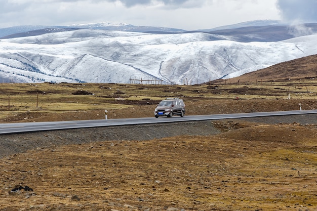 Bestelwagenauto op de weg, Mooie de winterweg in Tibet onder sneeuwberg Sichuan, China