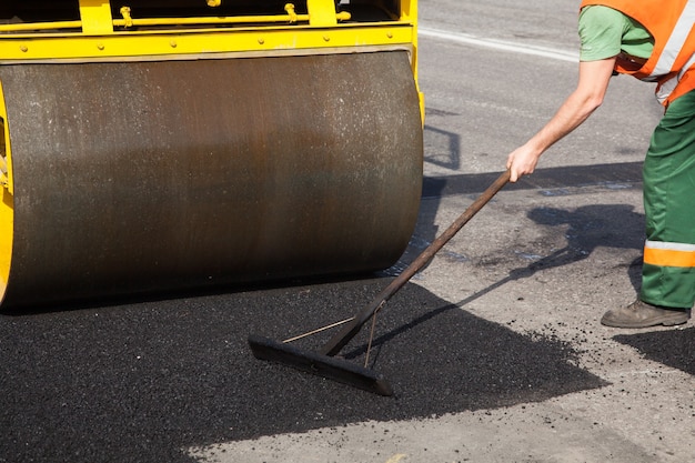 Bestratingsmachine die vers asfalt of bitumen op de grindbasis legt tijdens de aanleg van snelwegen