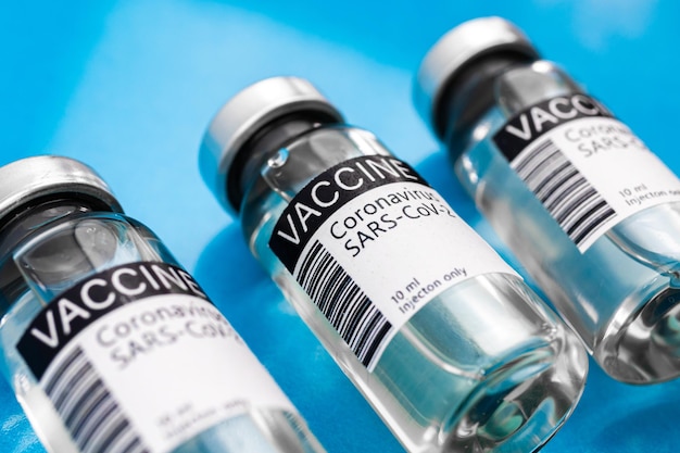 Bestrijd het coronavirusconcept met vaccinflesjes op de laboratoriumachtergrond, vaccinatieachtergrond met glazen flessen