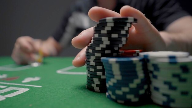 Ставка случайная азартная игра действие крупный кадр человека, ставящего фишки на покерный стол человек делает ставку с фишками на