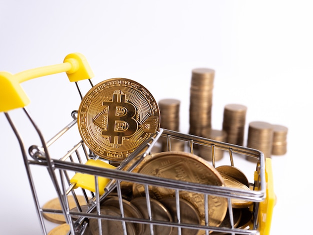 Betaal cryptovaluta: de supermarktkar is gevuld met gouden munten van bitcoin op een witte achtergrond. Kopieer ruimte