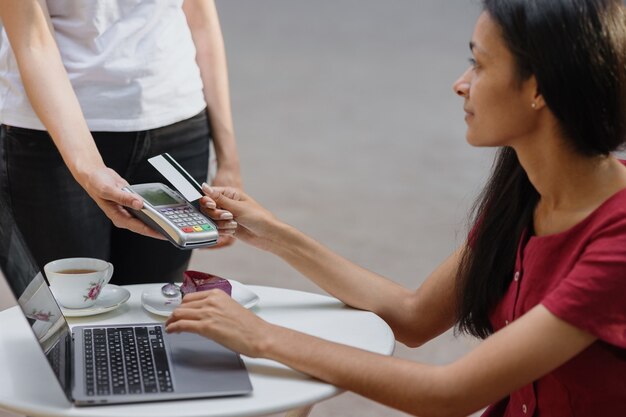 Betaling per kaart contactloos betalen met bankkaart of smartphone Afrikaanse vrouw betaalt voor een bestelling