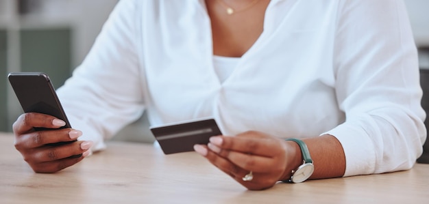 Betalingen bankieren en winkelen wordt gedaan door een vrouw met een creditcard en telefoon Vrouwelijke ondernemer zakenvrouw of baas betalen voor een product op de internet-app of website online op het werk