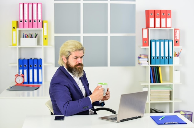 Better opportunity mature male boss businessman drink morning coffee serious entrepreneur in modern office business success successful bearded ceo in jacket confident man manager at laptop