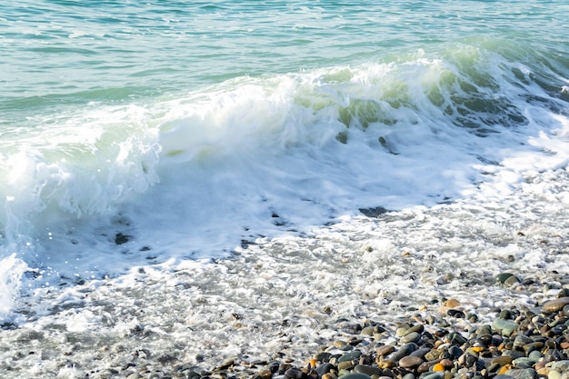 晴れた日のビーチコーストで波と水しぶきのある美しい海の景色