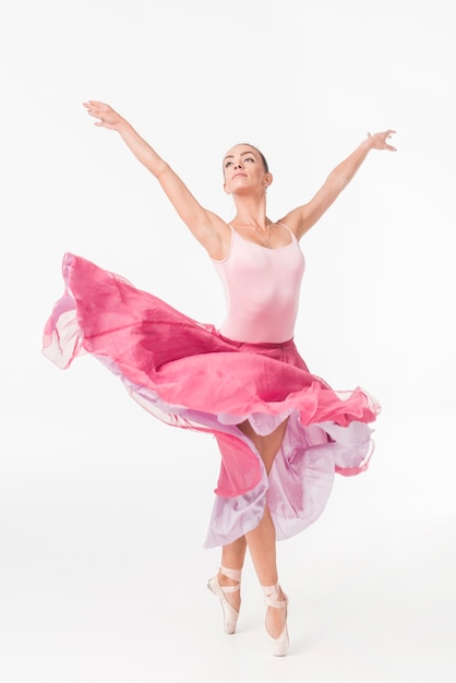 Foto bevallige ballerina in het roze tutu stellen tegen witte achtergrond