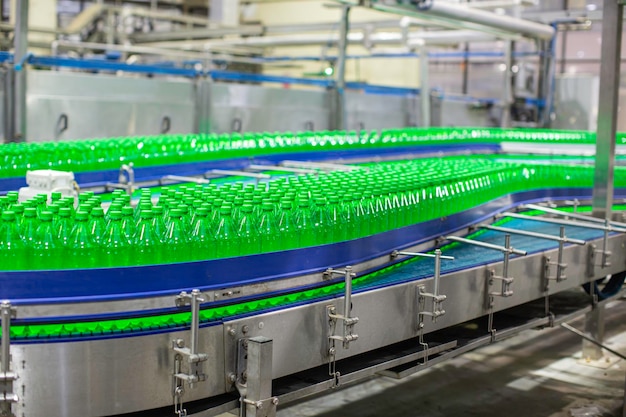 Beverage factory interior Conveyor flowing with bottles green for water