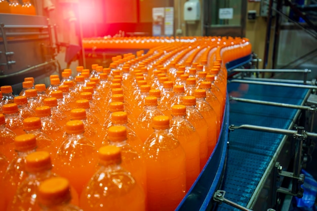 Beverage factory interior. Conveyor flowing with bottles for juice or water.