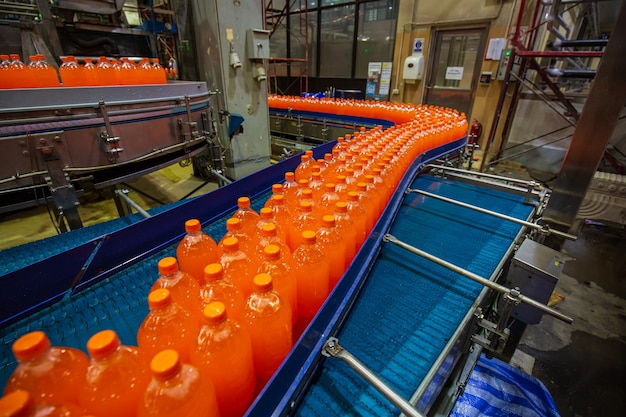 Beverage factory interior. Conveyor flowing with bottles for juice or water.