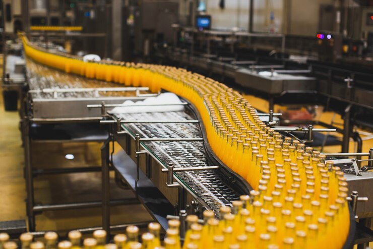 Photo beverage factory interior. conveyor flowing with bottles for juice or water.