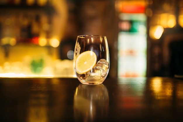 Beverage with slice of lemon and ice cubes