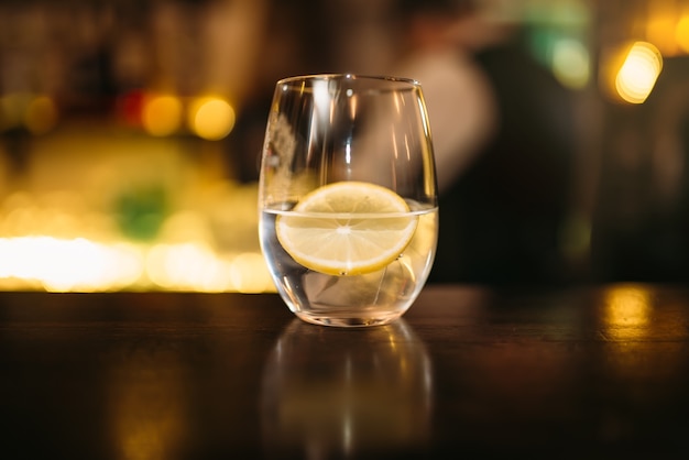 Beverage with slice of lemon and ice cubes