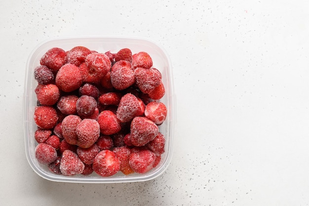 Bevroren aardbeien en kersen in container op witte achtergrond kopie ruimte