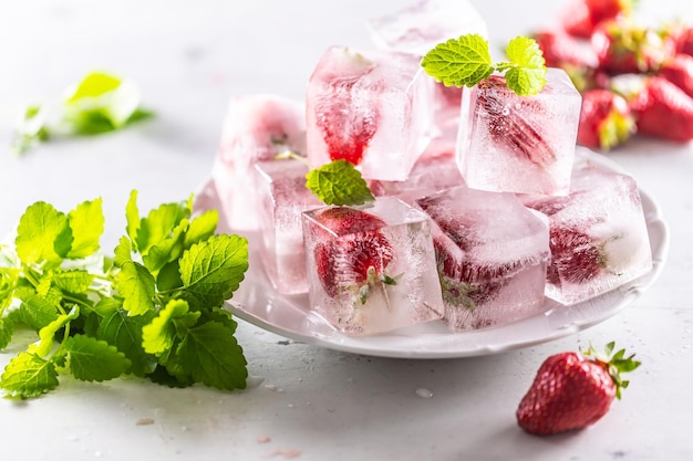 Bevroren aardbeien in ijsblokjes op een bord