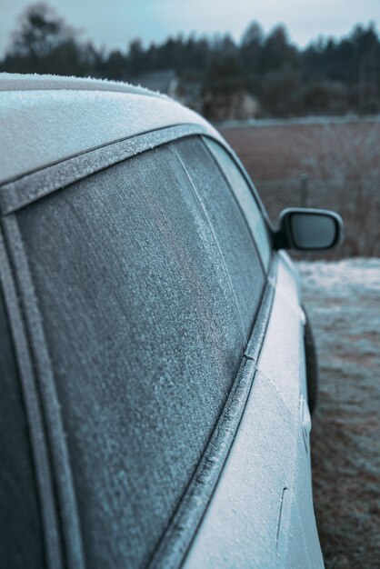 Bevroren auto aan de buitenkant parkeren Vervoer in de winter Voertuig close-up met bevroren voorruit en ramen