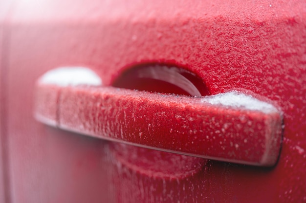 Bevroren auto deurklink Close-up van auto deurklink en slot bedekt met ijs tijdens winterstorm Concept van paraatheid en veiligheid tijdens het rijden in de winter