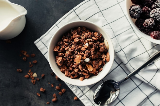 Bevroren bramen, muesli, room, handdoek op tafel. Onscherpe achtergrond. Hoge kwaliteit foto