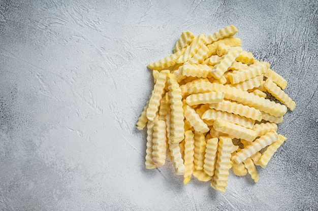 Bevroren Crinkle Frieten Aardappelsticks. Witte achtergrond. Bovenaanzicht. Ruimte kopiëren.