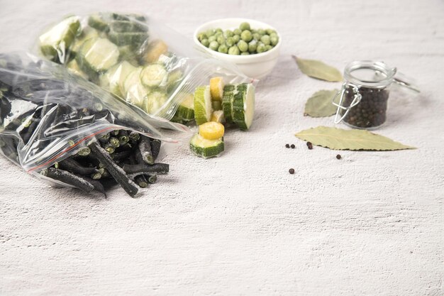 Bevroren groenten snijbonen courgette en groene erwten op een lichte achtergrond