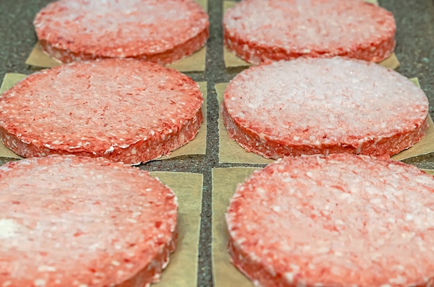 Bevroren hamburgervlees op tafel voor het grillen, ontdooien voor het grillen.