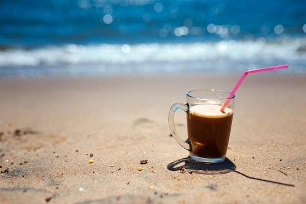 Bevroren koffie latte op een strandoceaan en een zeegezicht