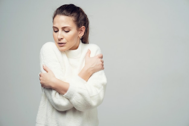 Bevroren koude zonnebaden in een warm wit jasje kijkend naar een donkerbruine vrouw