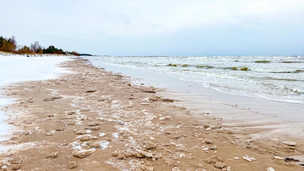 Bevroren kust in de winter met besneeuwde duinen. Sfeervol winters zee- en strandlandschap zonder mensen.