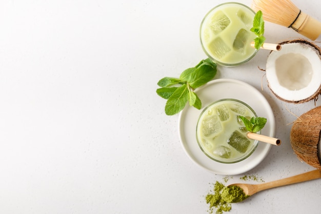 Bevroren latte groene matchathee met kokosnoot op witte achtergrond. Uitzicht van boven.