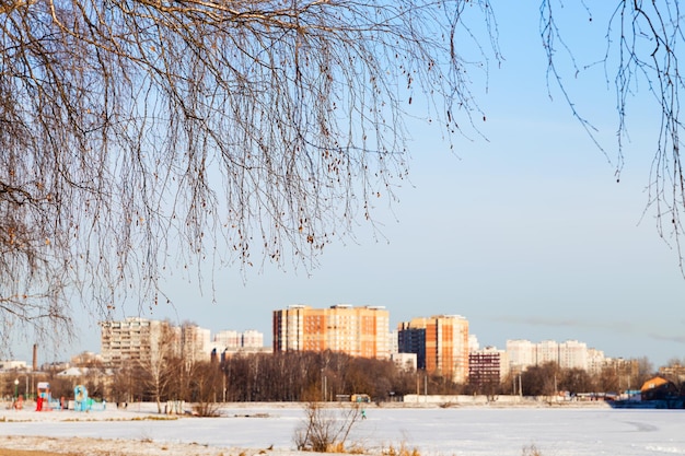 Bevroren meer en appartementshuizen in de stad in de winter
