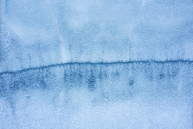 Bevroren meer met een grote scheur op het oppervlak vanuit luchtfoto bovenaanzicht. Natuurlijke winter achtergrond.