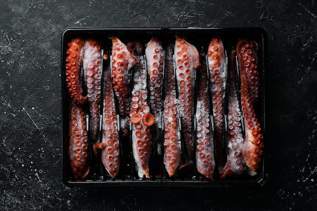 Bevroren octopus tentakels in een plastic doos Bovenaanzicht Plat liggend