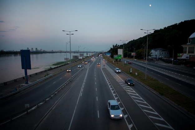 Bewegend beeld in Kiev 's nachts in de zonsondergang. Soort verkeer op een drukke straat bij zonsondergang, zachte focus