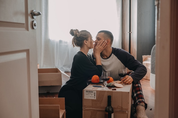 Foto bewegende dagviering jong koppel verhuist naar nieuw huis jong gelukkig stel jonggehuwden familie drinken