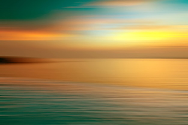 Beweging wazige achtergrond van breking in water. Panoramisch dramatisch uitzicht op de oneindige zonsondergang op de zee in de schemering.