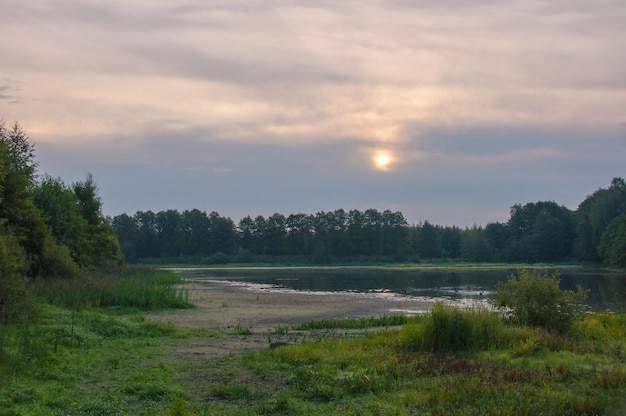 Bewolkte dageraad boven een bosmeer Moskou regio Rusland