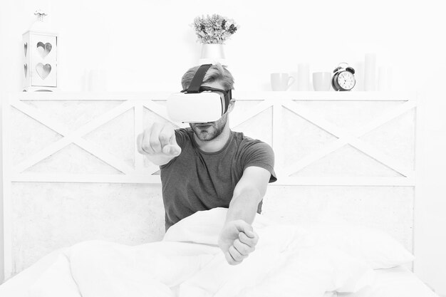 Bewust ontwaken Keer terug naar de realiteit Man verken vr terwijl hij ontspant in bed Ontwaken uit virtual reality VR-technologie en toekomstige VR-communicatie Opwindende indrukken Gaming augmented space