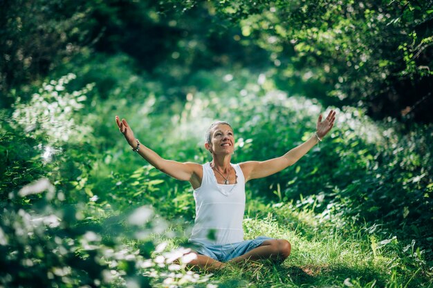 Foto bewustzijnsmeditatie bewustzijnsvrouw zit op de grond met open armen