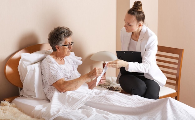 Foto bezoek van senior maatschappelijk werker aan een oude vrouw